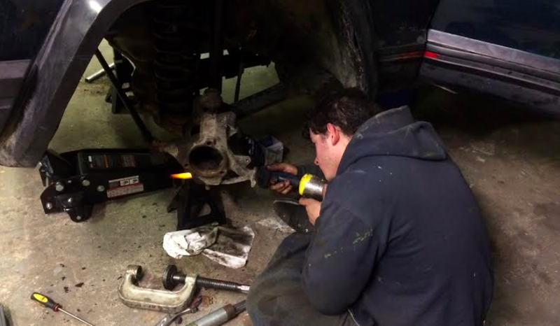 Santiago heats up the lower ball joint before trying to remove the knuckle from the axle.